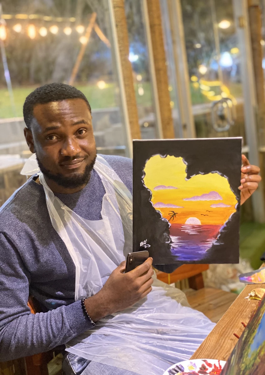 Bright holding one of his paintings